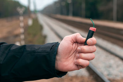 Midsection of man holding cigarette