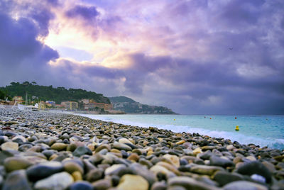 Stones on beach against sky