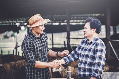 Financial advisor shaking hand with farmer at farm