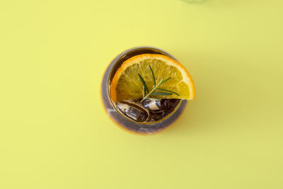 Directly above shot of lemon slice against yellow background