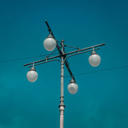 Low angle view of street light against blue sky