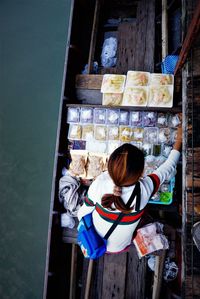 Directly above shot of woman in boat on river at floating market 