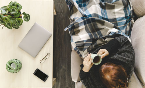 High angle view of woman having tea while sitting at home