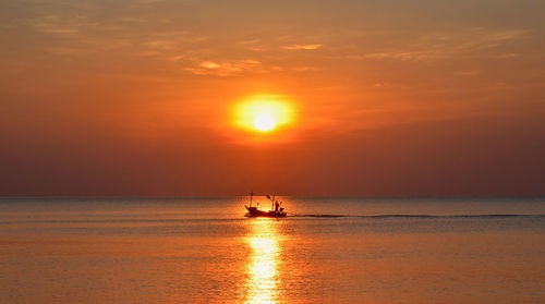 Scenic view of sea against orange sky