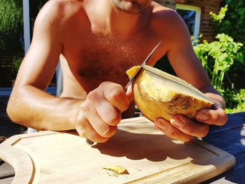 Midsection of man holding ice cream on table