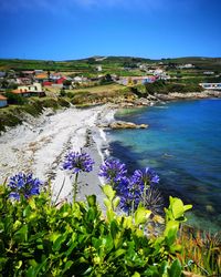 Scenic view of blue sea and buildings against sky