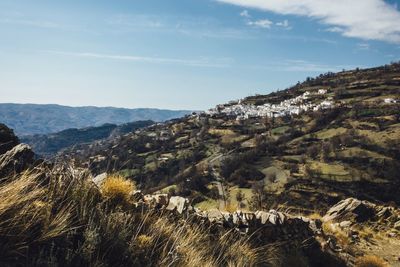 Low angle view of houses on mountain against sky