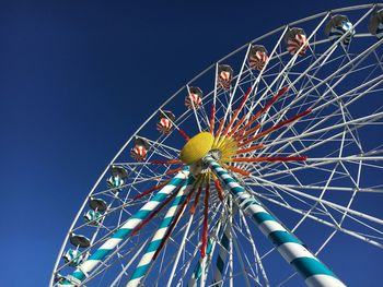 Low angle view of ferris wheel against blue sky