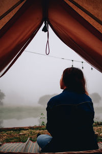 Rear view of woman sitting on mountain