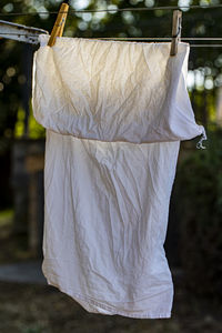 Close-up of white clothes drying on clothesline