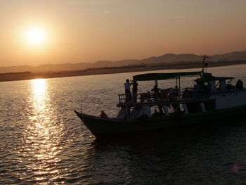 Boat sailing on sea against sky during sunset