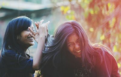 Cheerful friends against trees at park