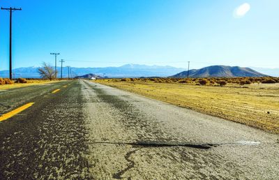 Road by mountains against clear sky