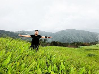 Young woman with arms outstretched on mountain