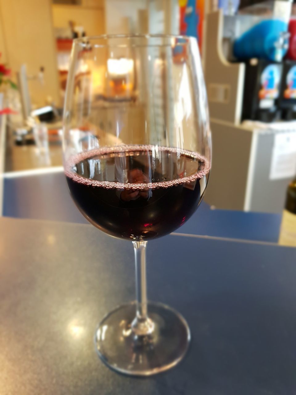 CLOSE-UP OF GLASS OF WINE ON TABLE