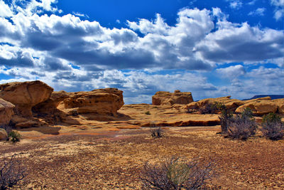 Scenic view of desert against cloudy sky