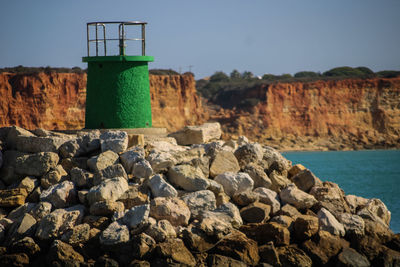 Rocks by sea against sky