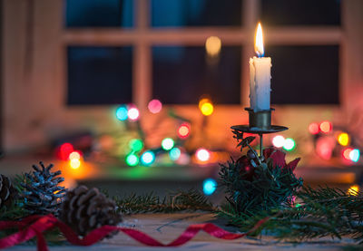 Close-up of illuminated candle on table