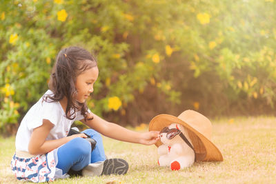 Side view of girl sitting on land