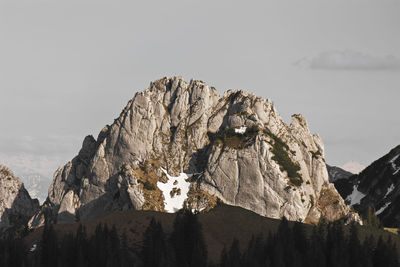 Low angle view of rocky mountains against clear sky