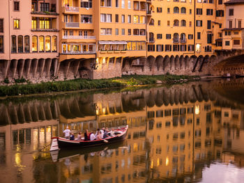 Boats in river against buildings in city