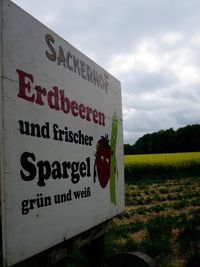 Information sign against cloudy sky