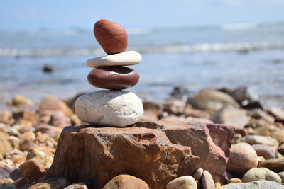 Close-up of pebbles on beach against sky