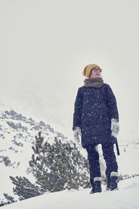 Man with umbrella standing against sky