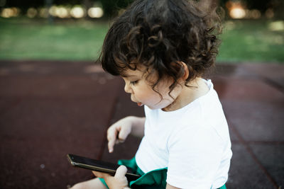 Side view of cute boy holding camera