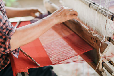 High angle view of woman working on loom in factory