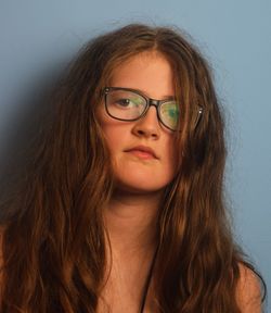 Portrait of girl with brown hair against wall