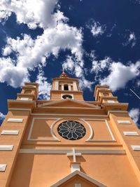 Low angle view of clock tower amidst buildings against sky