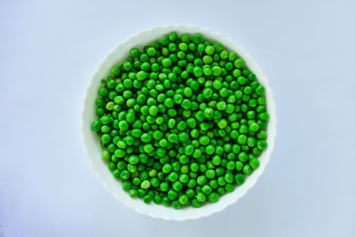 Directly above shot of green peas on white background