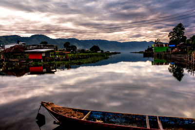 Panoramic view of lake and buildings against sky during sunset