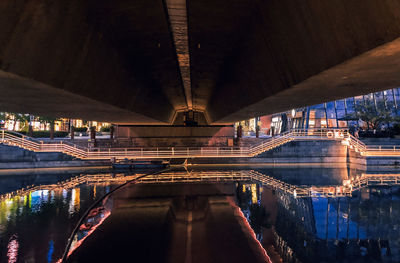 Illuminated bridge over river in city at night