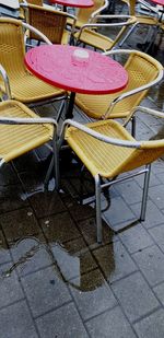 Empty chairs and tables at sidewalk cafe in rainy season