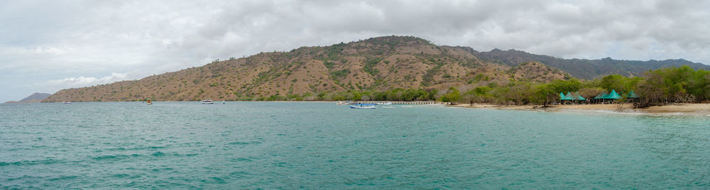 Scenic view of sea and mountains against sky