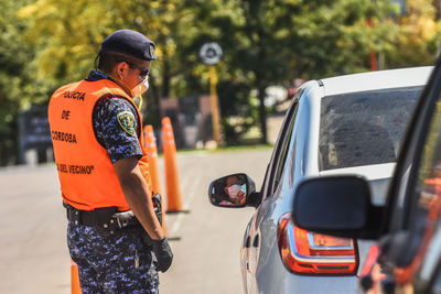 Man holding camera while standing by car