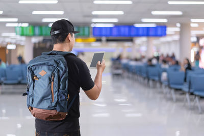 Rear view of man standing at airport