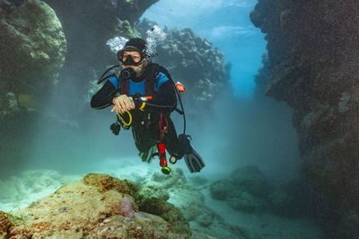 Scuba diver exploring a canyon at the great barrier reef in australia