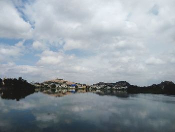 Scenic view of lake by buildings against sky