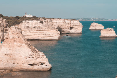 Rock formations by sea against sky