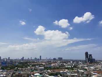 Aerial view of buildings in city against sky