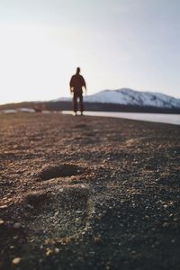 Rear view of silhouette man walking on mountain