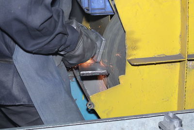 Midsection of manual worker working at factory