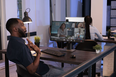 Side view of man using laptop at office