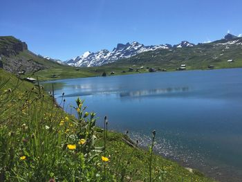 Scenic view of lake by mountains against sky