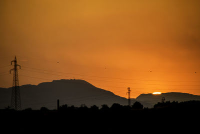 Silhouette landscape against sky during sunset