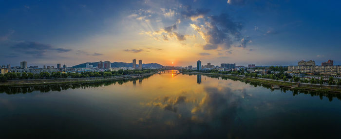 Reflection of urban buildings in the water at sunset