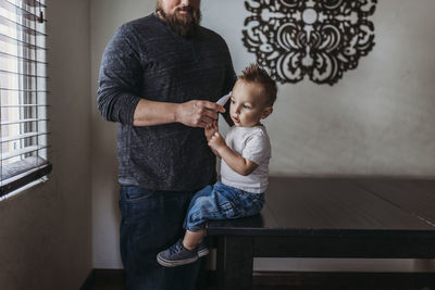 Midrange view of father taking young sons temperature at home